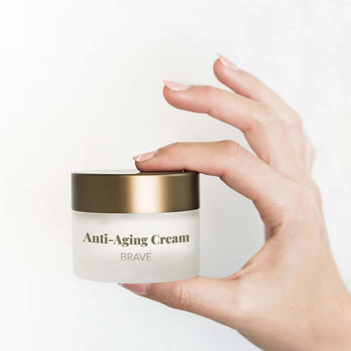En kvindes hånd holder æsken med CBD anti-aging creme + retinol