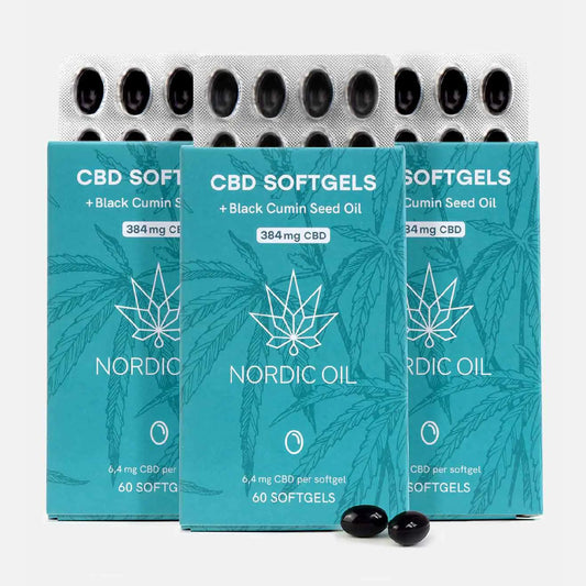 Tre blågrønne Nordic Oil CBD softgel-æsker med sortkommen frøolie og to sorte softgels foran.