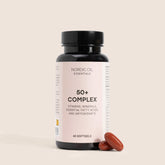 Nordic Oil Essentials 50+ Complex kosttilskud i mørk glasflaske med lyserød etiket og to røde bløde gelkapsler ved siden af