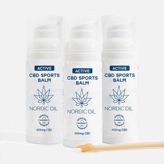 Tre hvide Nordic Oil Active CBD Sports Balm-flasker med blå logo og 400 mg CBD, med to træ-matches i forgrunden.