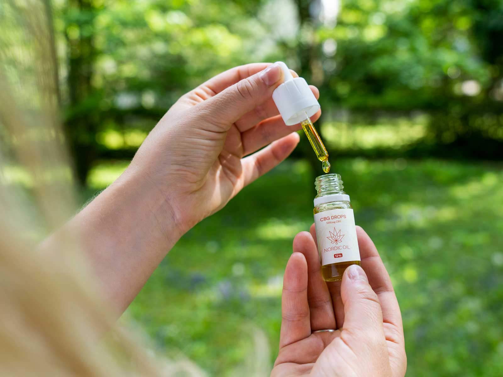 En kvinde bruger CBG-olie (12%) i naturen