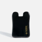 Sort, glat plastikgenstand med gyldent Nordic Cosmetics-logo