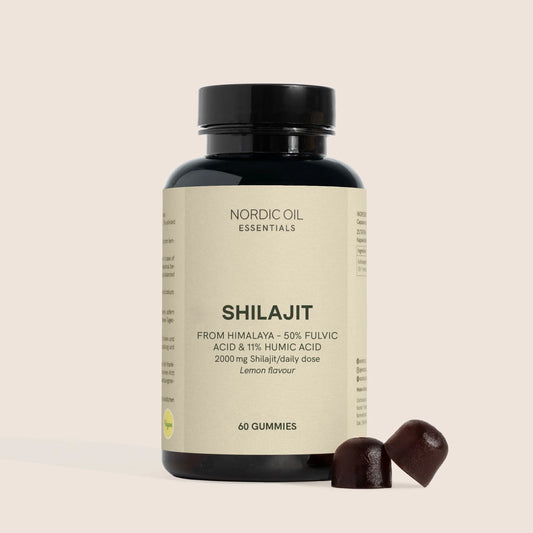 Flaske med Nordic Oil Essentials Shilajit gummies og to mørkebrune gummies ved siden af på beige baggrund