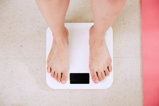 En person kontrollerer deres kropsvægt med en vægt