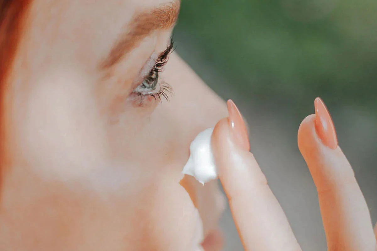 En kvinde anvender CBD Nat Cream + E Vitamin på sit ansigt.
